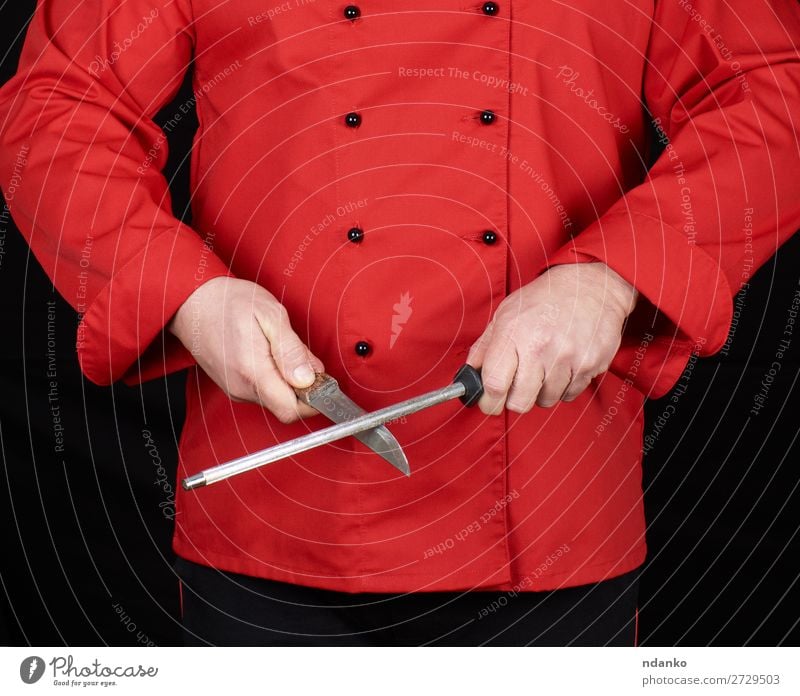 chef in red uniform sharpens a knife Knives Kitchen Restaurant Profession Cook Human being Man Adults Hand Steel Stand Red Black blade Caucasian chopping