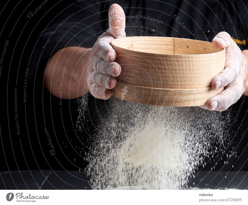 man sifts white wheat flour Dough Baked goods Bread Nutrition Table Kitchen Cook Human being Man Adults Hand Sieve Wood Movement Make Fresh Black White Baking