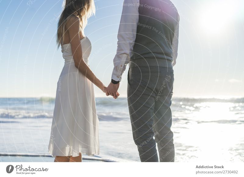 Beautiful bridal couple posing on shore Couple Beach Happiness seaside holding hands Cheerful Exterior shot Together Contentment Summer Dress Wedding