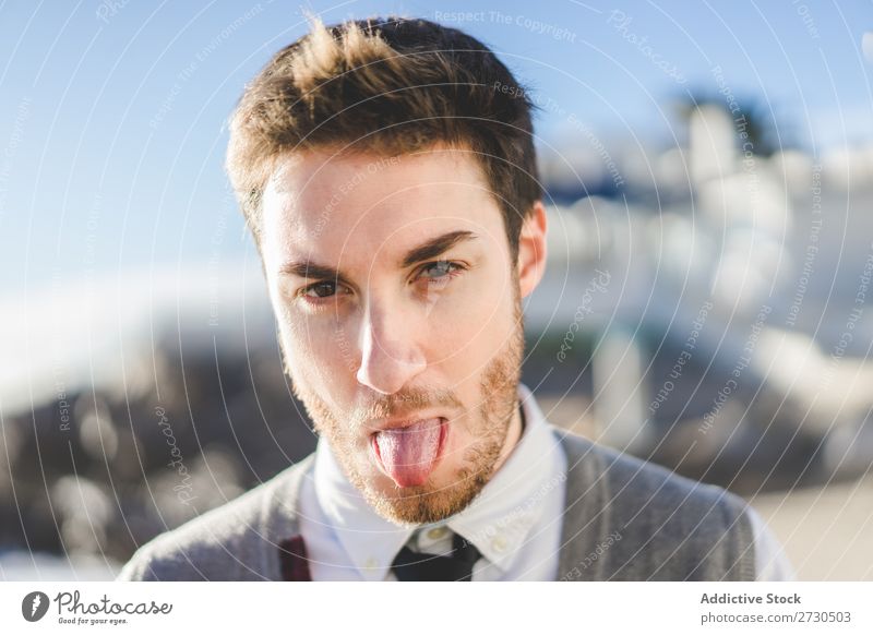 Man showing tongue in sunlight tongue out Playful Sunlight human face Portrait photograph Grimace Happiness Excitement Playing Expression making face handsome