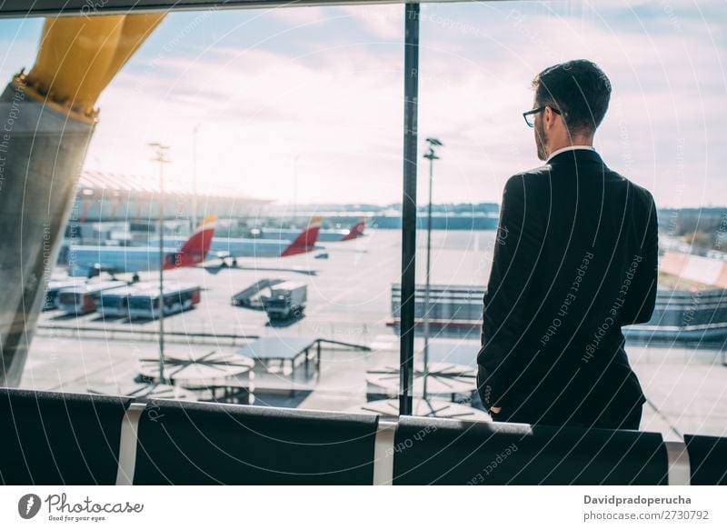 Back of a young business man standing with the suitcase at the airport waiting for the flight Airport Man Vacation & Travel Shadow Business Wait Airplane Gate