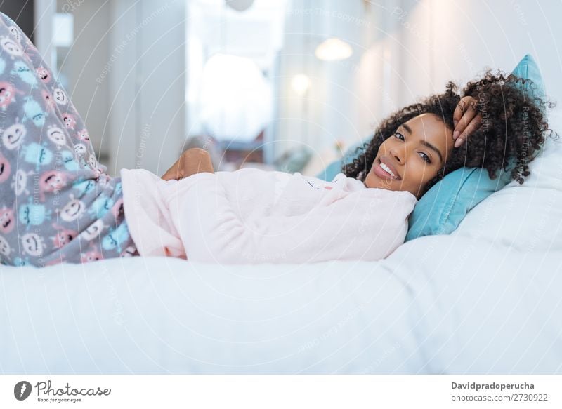 Happy beautiful young black woman relaxed lying down in the bed Woman Black Smiling Relaxation Beautiful awake Cute Bed Cozy Winter Pyjama pajama Cold