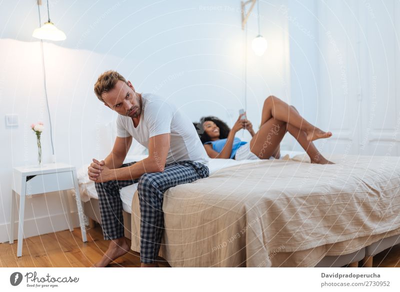 Young beautiful interracial couple in bed stressed with infidelity problems Adults Couple Anger Bed Mixed race ethnicity Racing sports Youth (Young adults)