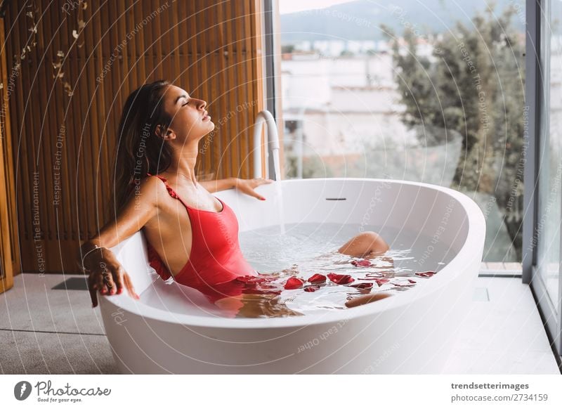 Woman in a modern bath tub Lifestyle Luxury Beautiful Body Skin Wellness Relaxation Spa Bathtub Bathroom Adults Flower To enjoy Modern Clean young girl Tub care