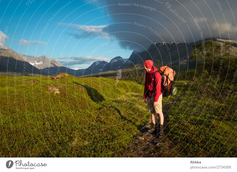 Cloud rolls over the mountains, man with red jacket and backpack stands on a path and looks into a valley variegated Clouds Valley hikers Red Orange Green Blue
