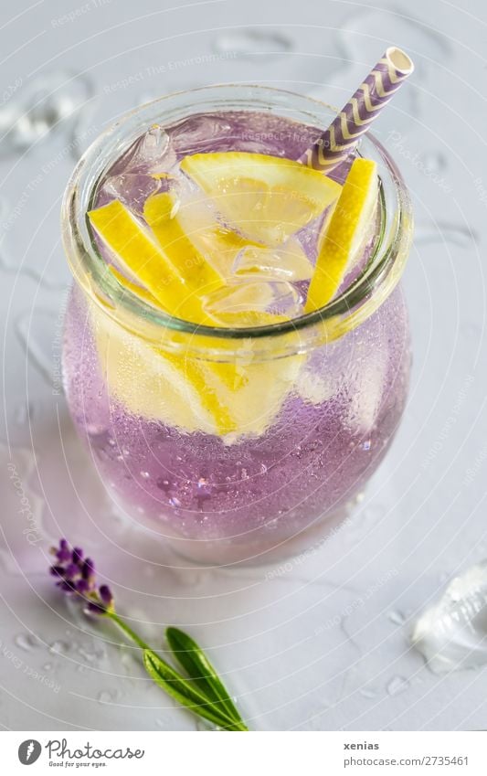 Cool aromatic water with lavender, lemon, ice cubes and drinking straw on a light table top with drops of water Beverage Lemon Lavender Ice cube Cold drink