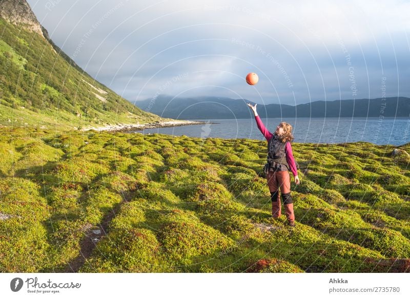 Young woman juggles with flotsam Playing Vacation & Travel Youth (Young adults) Nature Grass Coast Bay Fjord Ocean Norway Catch Flying To enjoy Contentment
