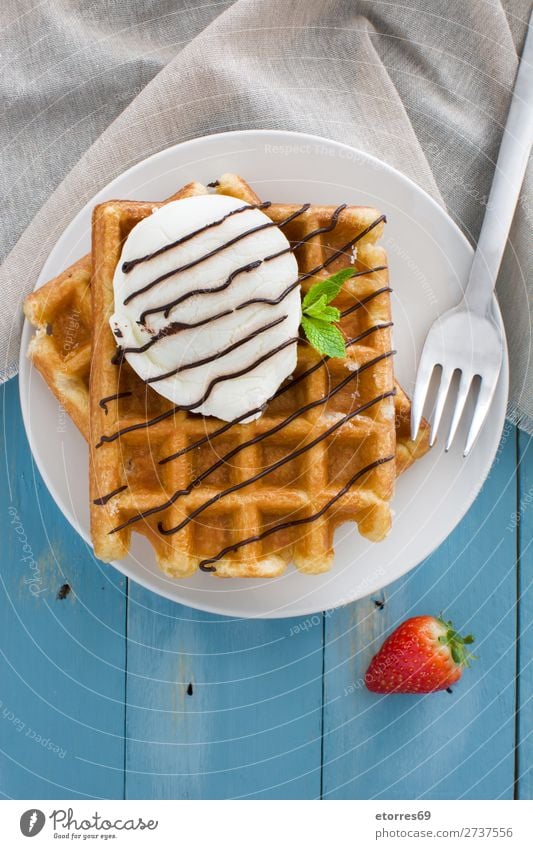 Belgian waffles with ice cream on blue wooden table Waffle Dessert Ice cream Belgium White Sweet Food background Breakfast wafer Mint Syrup Heap Strawberry
