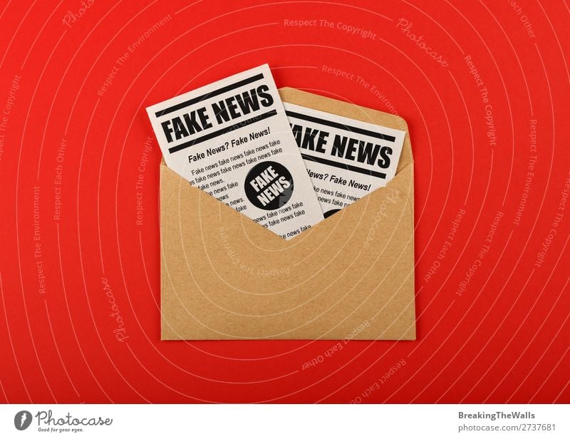 Envelope with FAKE NEWS newspapers over red Mail To talk Media Print media Newspaper Magazine Paper Sign Signs and labeling Brown Red False Information