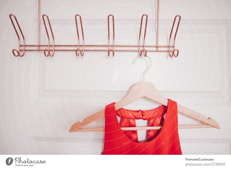 https://www.photocase.com/photos/2739695-coat-hanger-with-red-dress-on-copper-coloured-coat-hook-photocase-stock-photo-large.jpeg