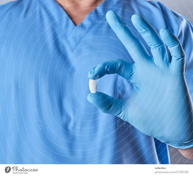 doctor in blue latex gloves holding a white pill Medical treatment Illness Medication Doctor Hospital Human being Hand Gloves Blue White Health care chemical