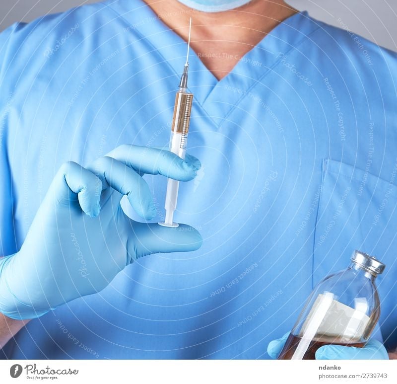male doctor in blue uniform holding a syringe Health care Medical treatment Nursing Illness Medication Science & Research Laboratory Doctor Hospital Human being