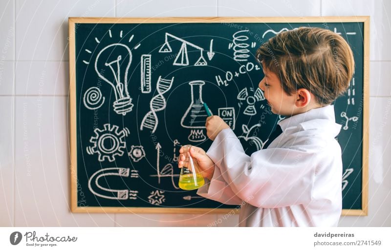 Boy dressed as chemist pointing at blackboard Happy Science & Research Child School Blackboard Laboratory Human being Boy (child) Man Adults Tie Blonde Smiling