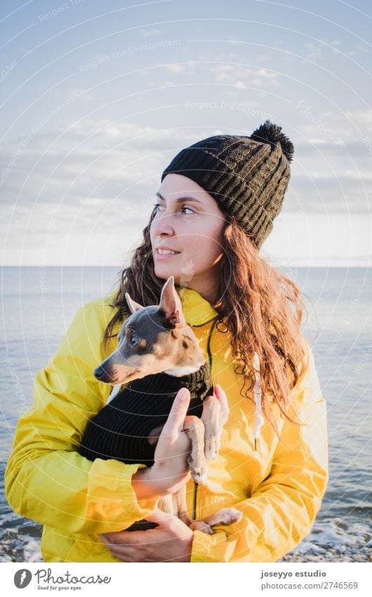 Woman with her little dog on the beach Lifestyle Relaxation Trip Freedom Sun Beach Winter Friendship 30 - 45 years Adults Nature Animal Horizon Coast Jacket
