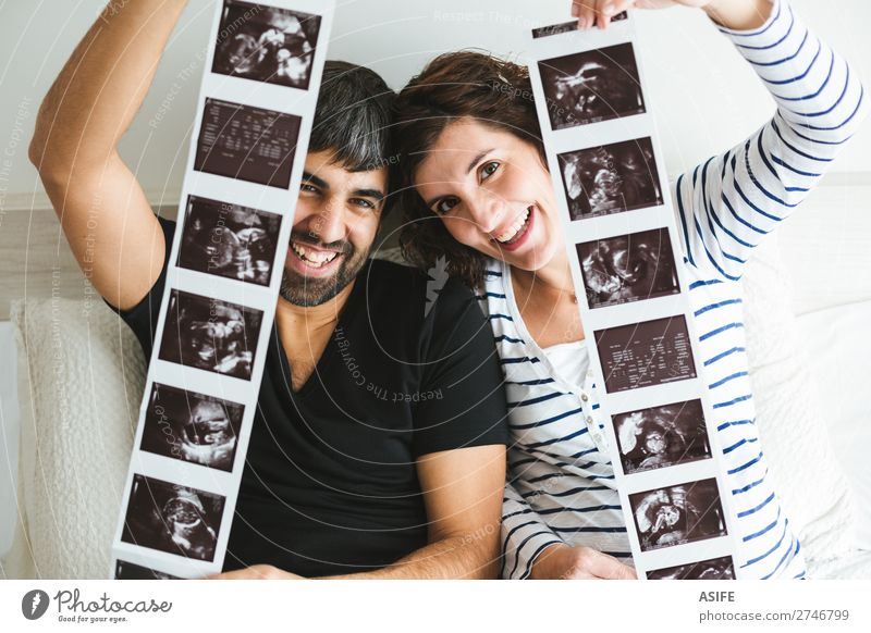 Happy pregnant couple showing ultrasound images of their baby Beautiful Life Baby Woman Adults Man Parents Mother Father Family & Relations Couple Smiling Love
