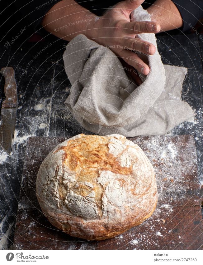 baked round bread on a board Bread Nutrition Table Kitchen Profession Cook Human being Hand Fingers Wood Make Dark Fresh Brown Black White Tradition chef Baking