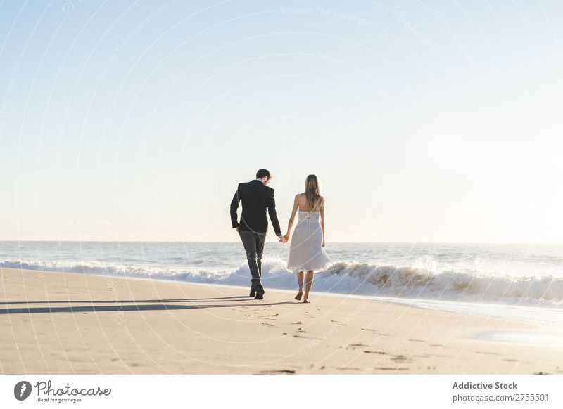 Romantic bride and groom strolling on beach Couple Bride Groom To go for a walk in love Beach romantic Relationship holding hands Dream Youth (Young adults)