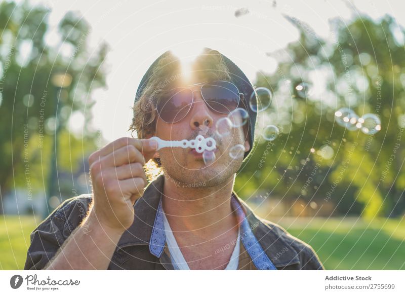 Man blowing soap bubbles in park Hipster Park Soap bubble romantic handsome Youth (Young adults) Playful Easygoing Modern Blow Posture Summer Playing Happiness