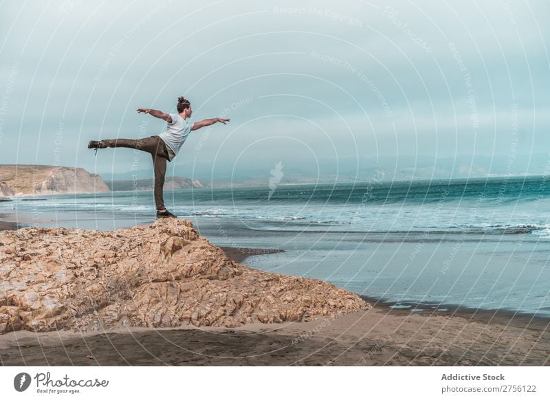 Man balancing on stone at sea Human being Coast Youth (Young adults) Ocean Balance Stone Yoga Meditation Tourist Landscape Vacation & Travel Hill Sand Water