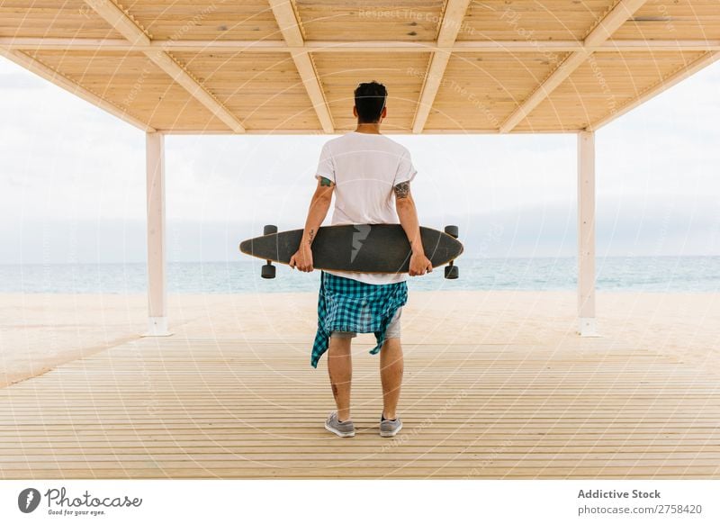 Man with skateboard looking at sea skateboarder Skateboard Ocean Coast Clothing Hip & trendy Leisure and hobbies Youth (Young adults) Vacation & Travel