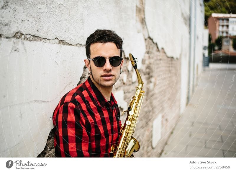 Smiling jazzman with sax Musician Man Sunglasses Self-confident Cool (slang) Cheerful Wall (building) Youth (Young adults) Jazz Saxophone instrument Musical