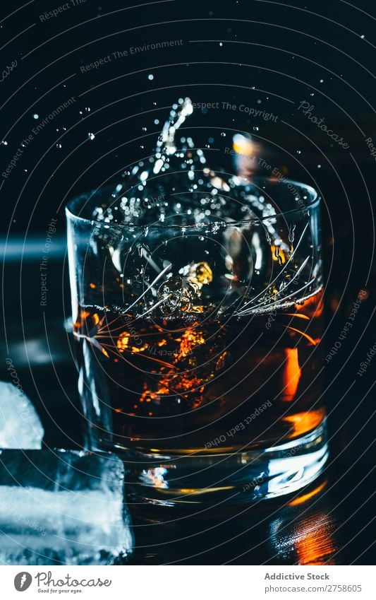Glass of splashing whiskey Alcoholic drinks Beverage Bourbon Brown Cocktail Cold Cool (slang) Crystal Cube Dark Drinking Drop Elegant Bird's-eye view glassware