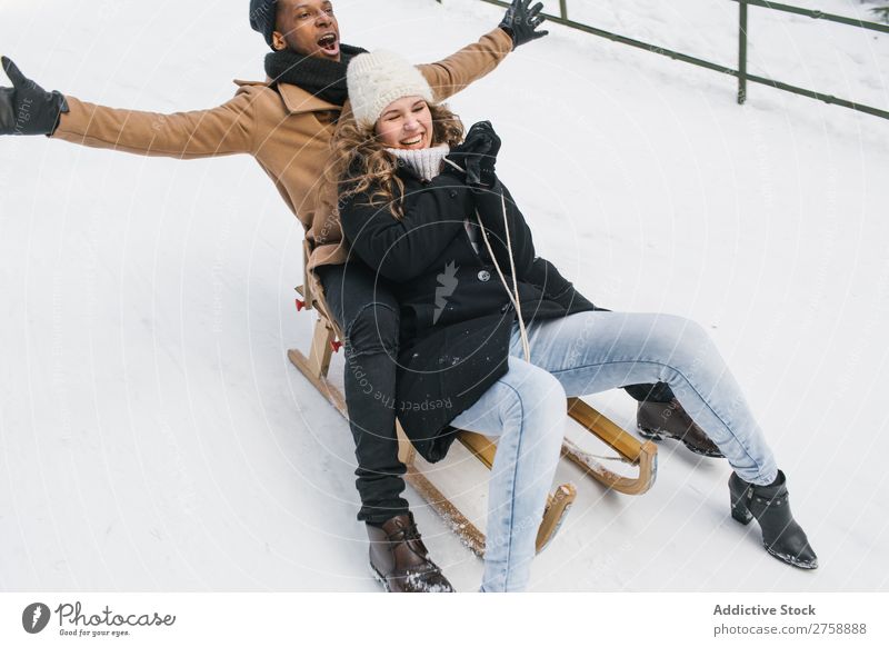 Couple riding sledge on snowy hill multiethnic Style warm clothes Easygoing Nature Sledge Winter Snow Beautiful Mixed race ethnicity Black Youth (Young adults)
