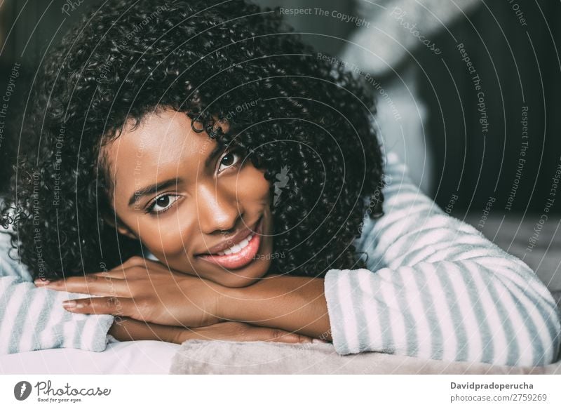 close up of a pretty black woman with curly hair smiling and lying on bed looking at the camera Woman Bed Portrait photograph Close-up Lie (Untruth) Black