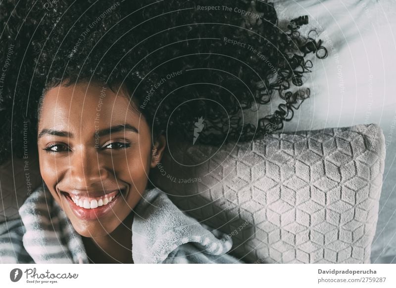 Beautiful black woman with curly hair smiling and lying on bed looking at the camera Woman Bed Black Smiling African pretty Bird's-eye view Close-up Curly hair