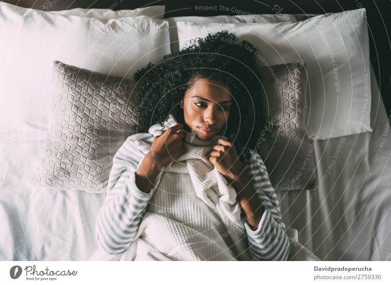 Beautiful thoughtful black woman with curly hair lying on bed looking away Woman Bed Black Considerate African pretty Bird's-eye view Close-up Curly hair