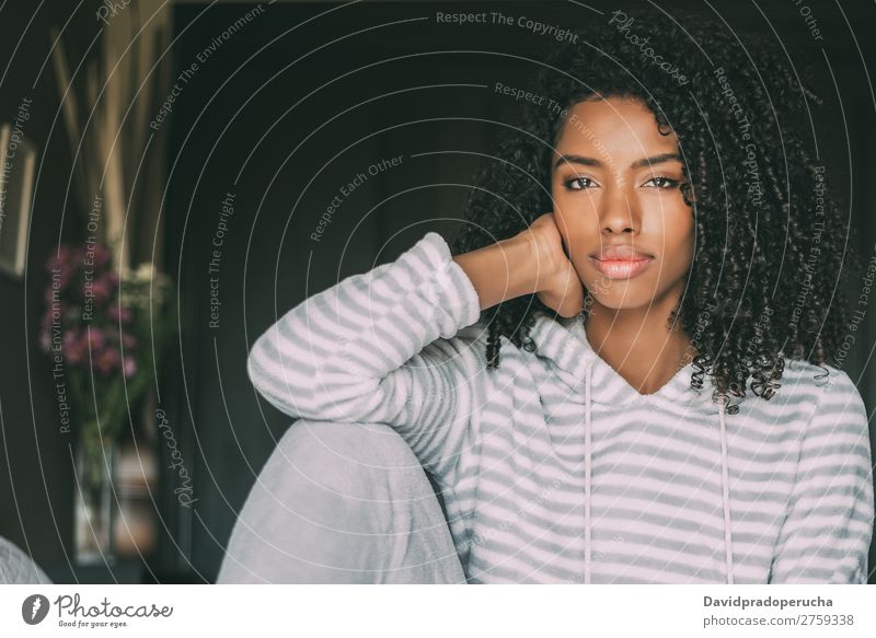 Beautiful thoughtful black woman sit on bed looking at the camera Woman Bed Black Considerate African Crops pretty Sit Close-up Curly hair Interior shot Resting