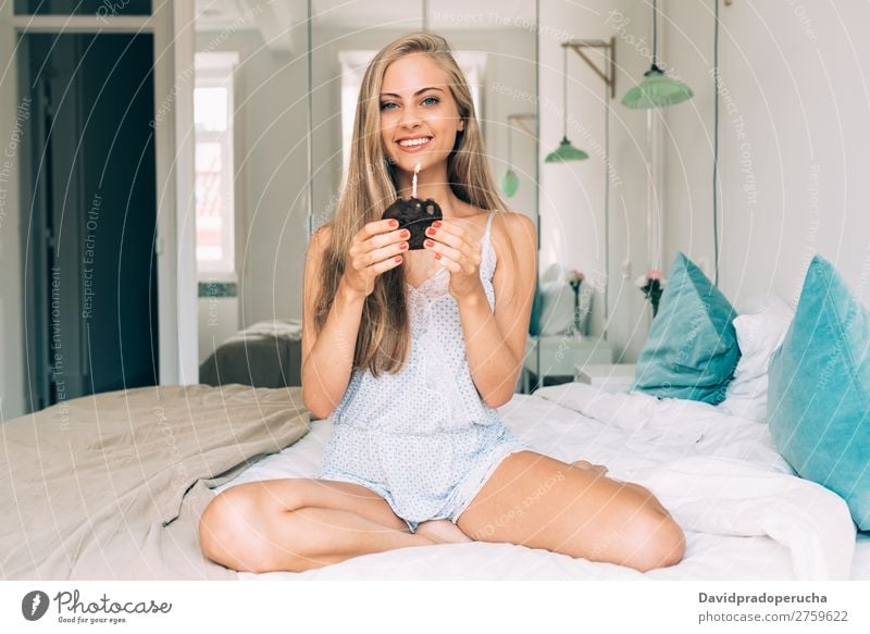 Young beautiful blonde woman in the bed blowing a candle in a chocolate muffin Woman Bed Bedroom Blonde Portrait photograph Muffin Cake Blow Candle Birthday