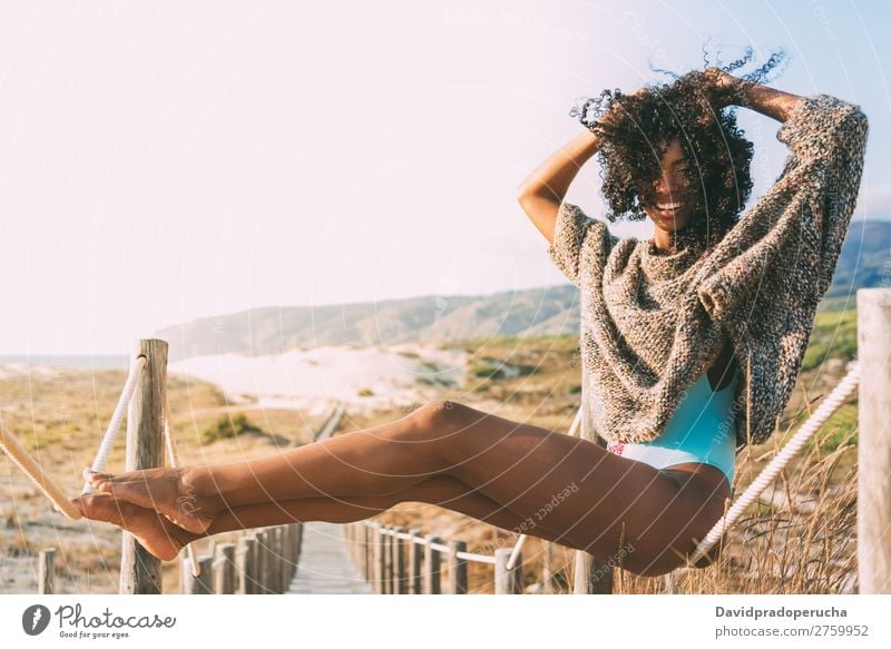 Beautiful young black woman sitting in a  wooden foot bridge at the beach Background picture Beach Bikini Black Bridge Coast Curly hair Destination Feet Hair