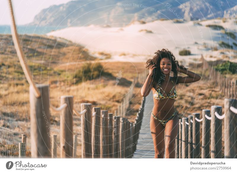 Beautiful young woman wearing a bikini running in a wooden foot bridge at the beach Beach Woman Bikini Black Bridge Background picture Coast Curly hair