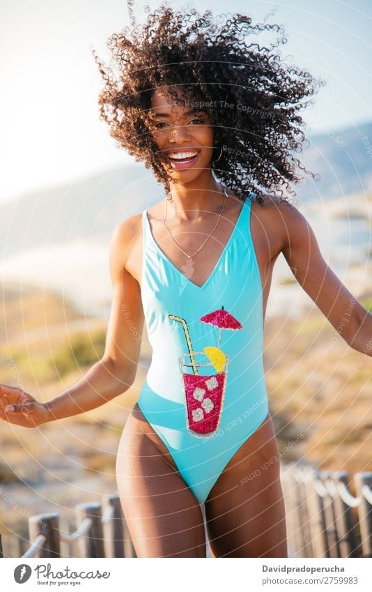 Happy beautiful young woman wearing a swimming suit in a wooden