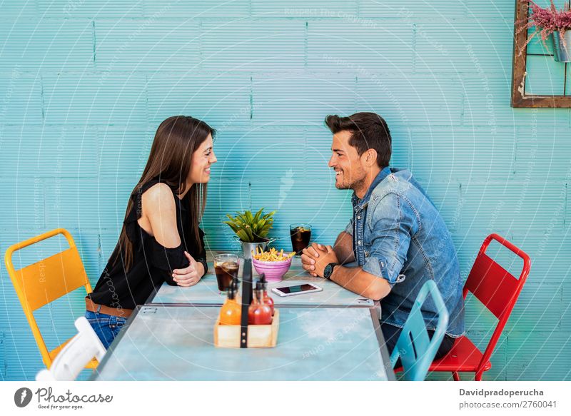 Happy young couple seating in a restaurant Adults Attractive Background picture Beautiful Blue Caucasian Coffee Cola Multicoloured Couple Drinking enjoying