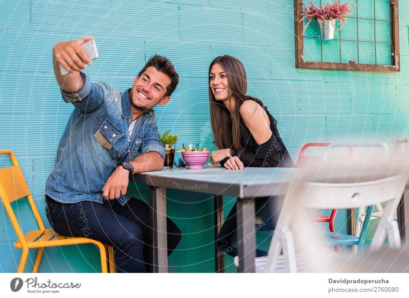 Happy young couple seating in a restaurant with a smartphone taking a selfie Adults Attractive Background picture Beautiful Blue Caucasian Coffee Cola