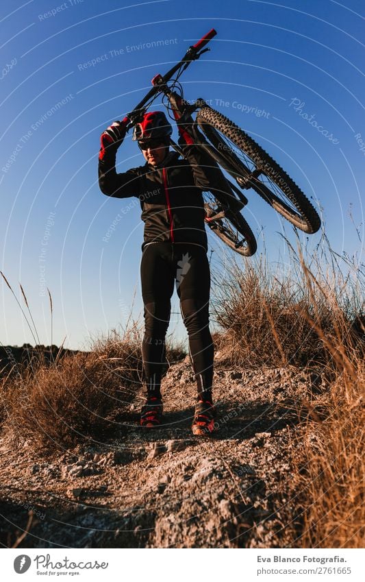 Cyclist holding the Bike at Sunset. Sports Concept. Lifestyle Relaxation Leisure and hobbies Adventure Summer Mountain Cycling Masculine Young man