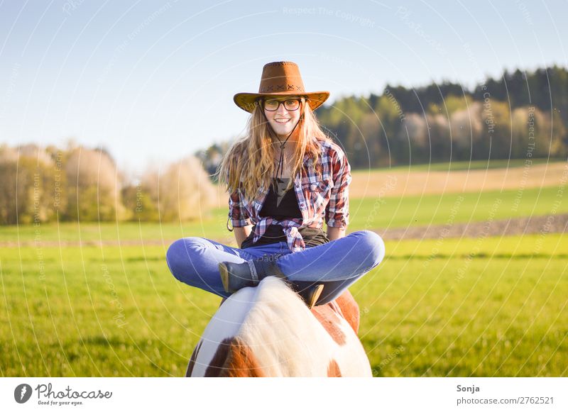 Young woman sitting cross-legged on a horse Lifestyle Joy Ride Vacation & Travel Feminine Youth (Young adults) 1 Human being 18 - 30 years Adults Landscape Sky