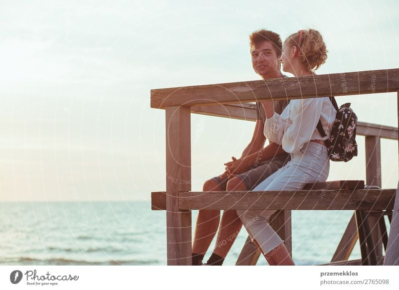 Couple of young woman and man sitting on a pier over the sea Lifestyle Joy Happy Leisure and hobbies Vacation & Travel Summer Ocean Human being Boy (child)