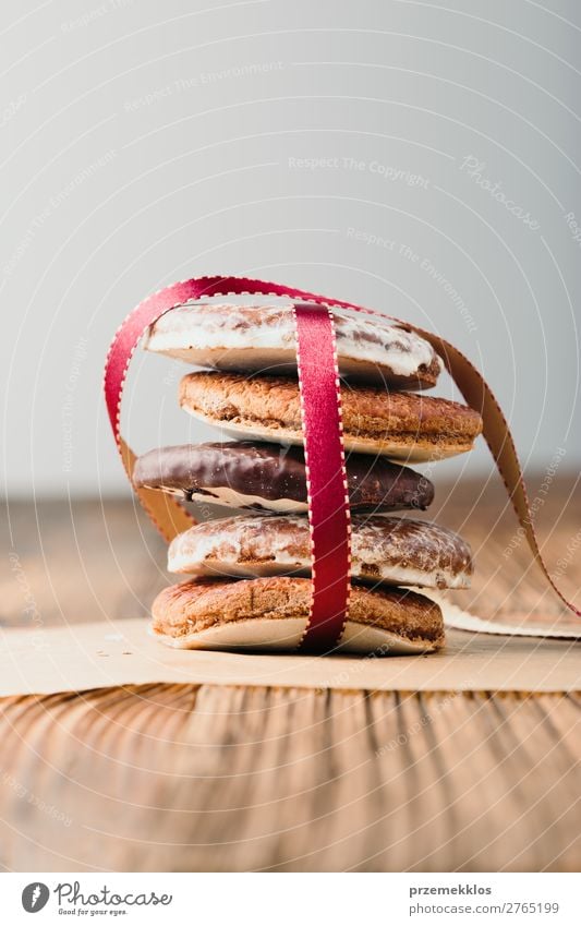 A few gingerbread cookies wrapped in red ribbon on wooden table Dessert Nutrition Eating Diet Table String To enjoy Delicious Brown Baking Bakery biscuit
