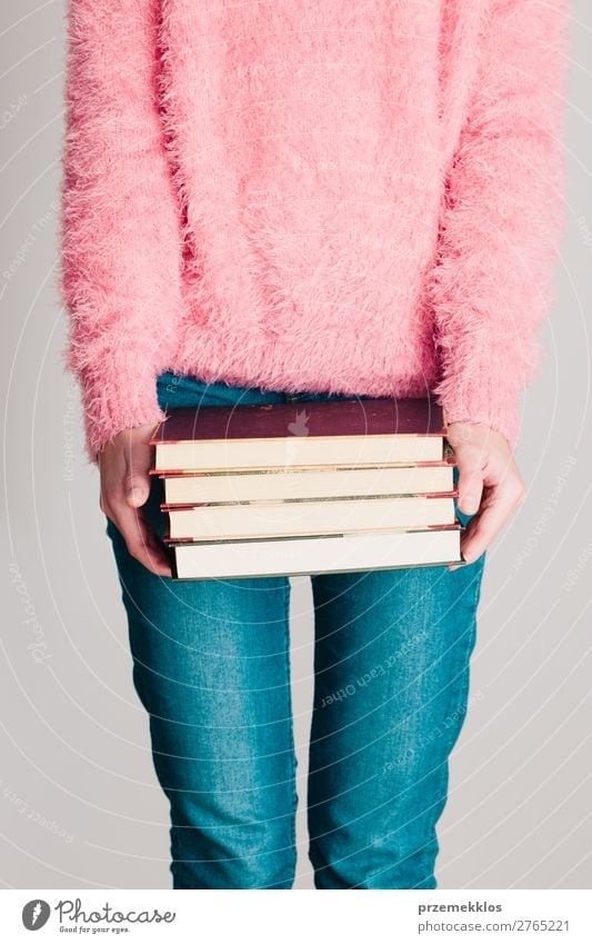 Young girl holding a few books Lifestyle Relaxation Leisure and hobbies Reading School Study Human being Woman Adults Youth (Young adults) 1 Book Library