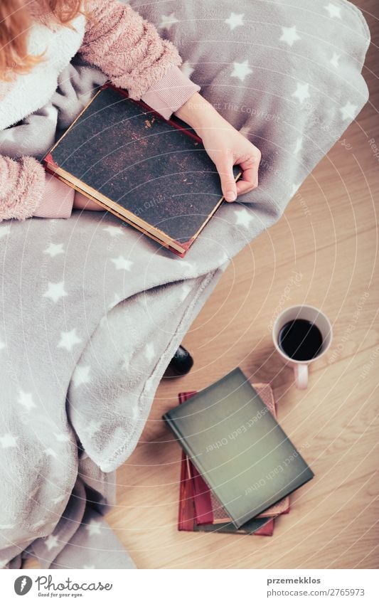Girl enjoying the reading a book and drinking coffee at home Coffee Lifestyle Relaxation Leisure and hobbies Reading Child Human being Woman Adults Book Warmth