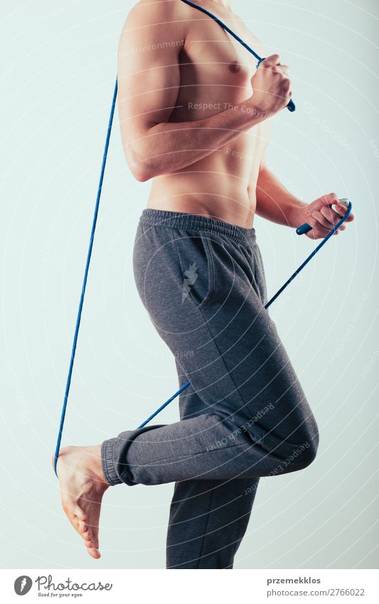 Young man holding skipping rope, doing exercises at home Lifestyle Sports Rope Human being Boy (child) Man Adults Fitness Jump Above Action Caucasian Practice