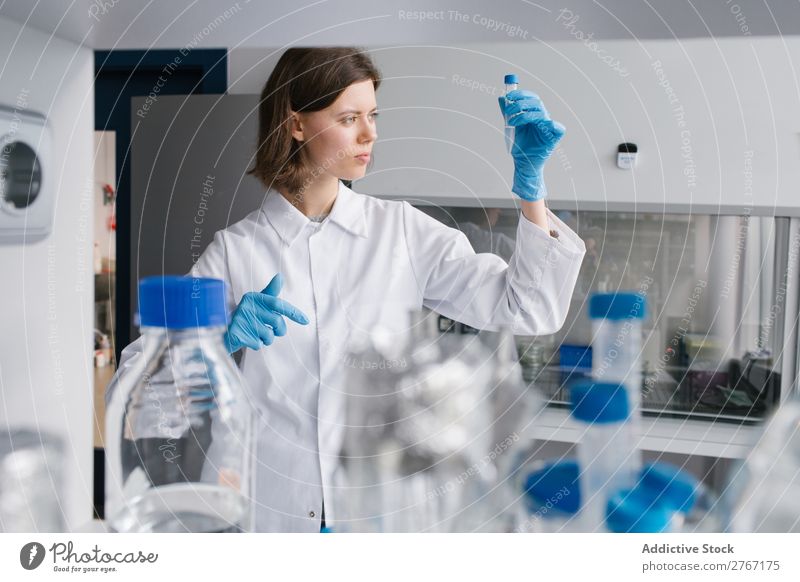 Worker looking at test tube Laboratory Work and employment Science & Research Woman Test tube Liquid pouring Putt Human being Scientist Medication Chemistry