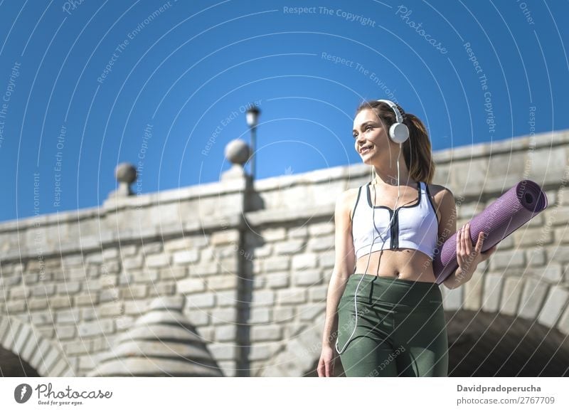 Woman walking with yoga and pilates mat and listening music Lifestyle Beautiful Body Wellness Relaxation Meditation Music Sports Yoga Human being Adults Nature