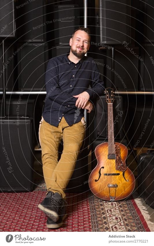 Guitarist sitting on guitar combo Man Shopping Looking into the camera seller Customer rows Musical Acoustic Equipment Human being Business Portrait photograph