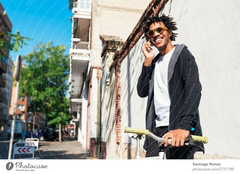 Afro young man using mobile phone and fixed gear bicycle. Man Youth (Young adults) African Black mulatto Mobile Bicycle fixie Telephone Lifestyle Stand Cycling