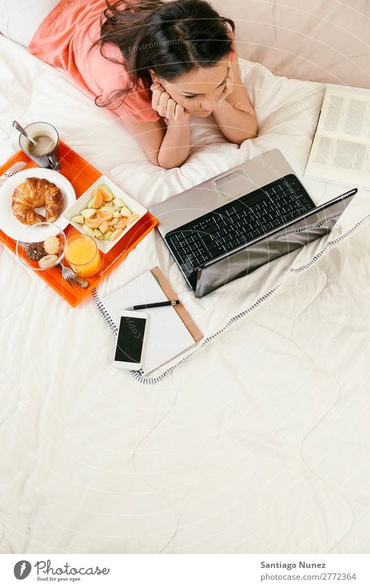 Woman watching the laptop computer and having breakfast Breakfast Bed Notebook Coffee Fruit Juice Orange juice Croissant Nutrition Work and employment
