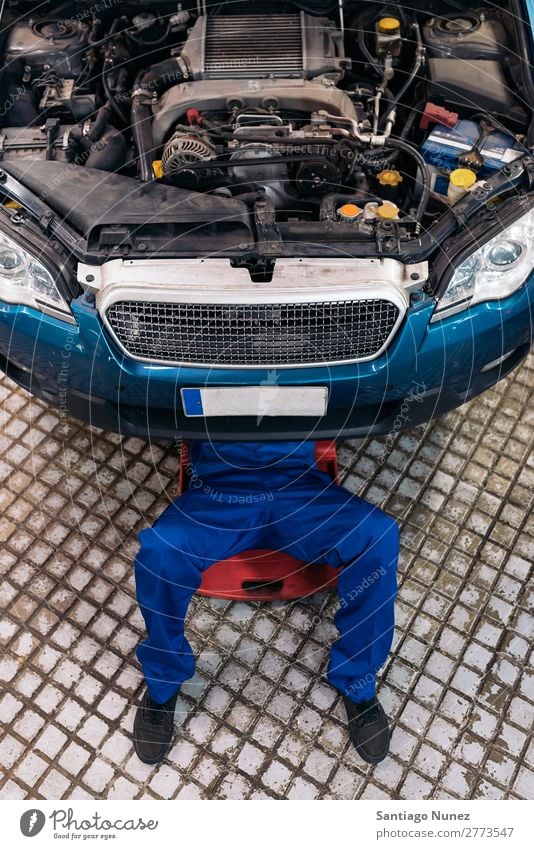 Professional Mechanic Repairing Car. Adults Man Blue Maintenance Vehicle Tool Engines Inspection Cheerful Dirty Fix Garage Happy Car Hood Work and employment